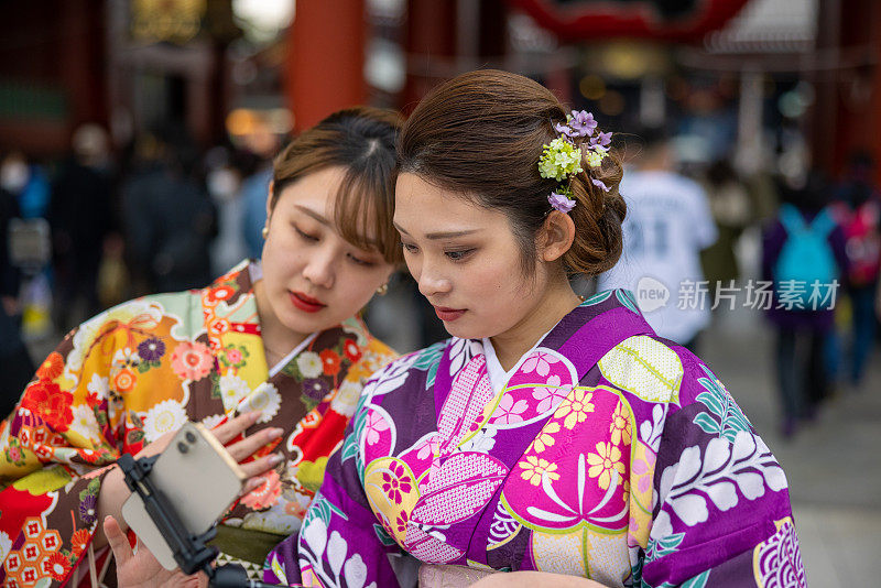 穿着和服的年轻女性朋友在旅游地点拍视频