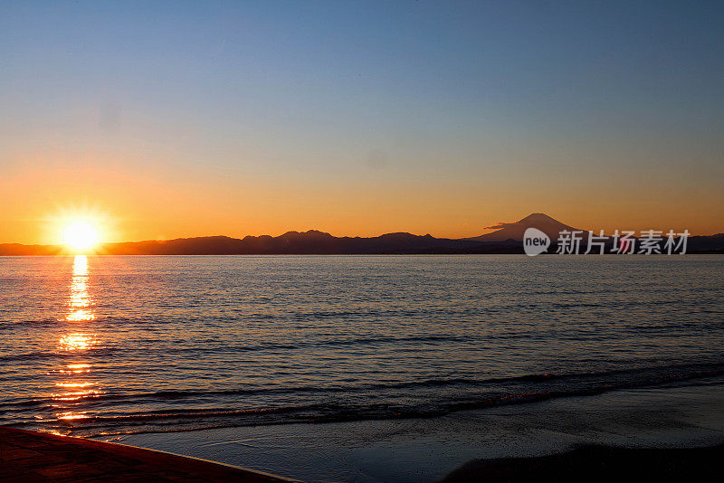 日落时，海滩上的剪影山映衬着天空