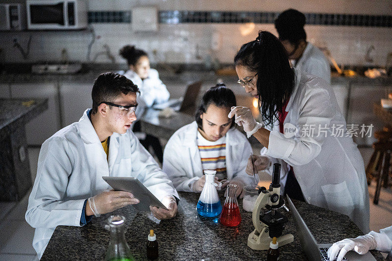 化学老师在学校或大学的实验室里教学生-包括有特殊需要的学生
