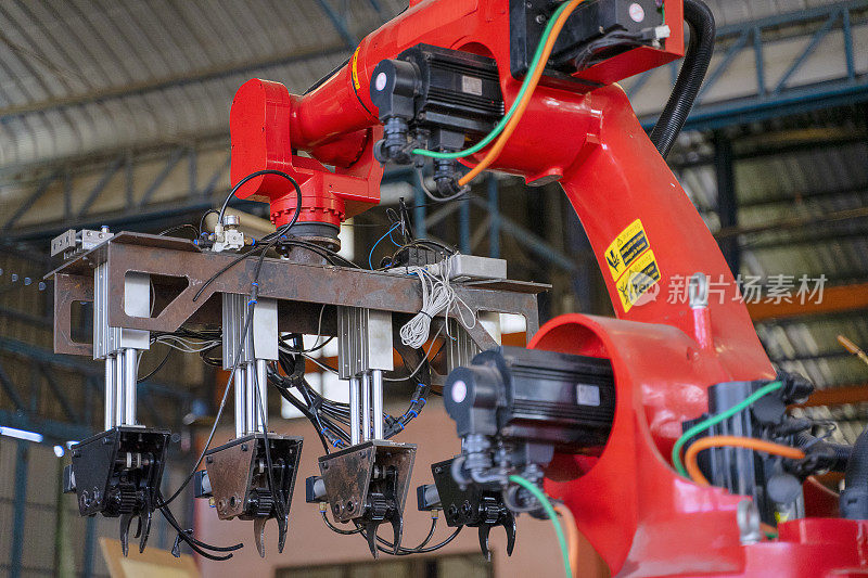 工人们在工厂里用机械手臂工作。