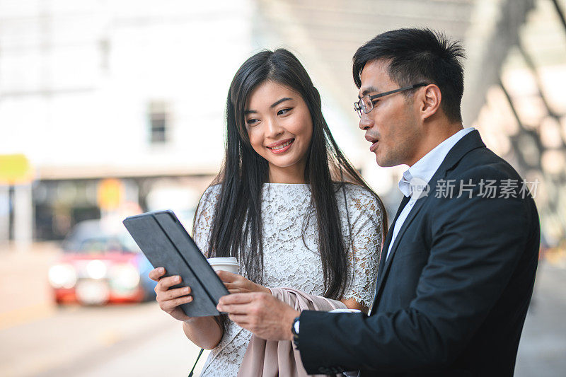 亚洲女商人和商人使用数码平板电脑