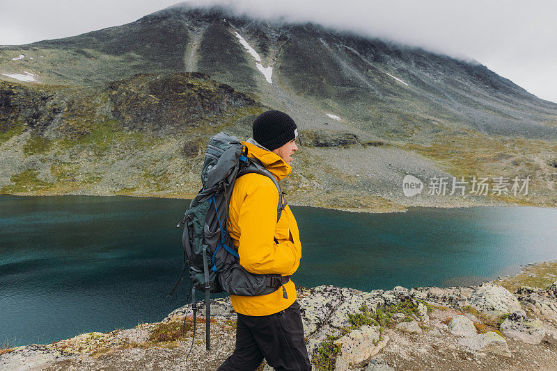 在挪威约顿海门国家公园，一名背着背包的男性徒步登山