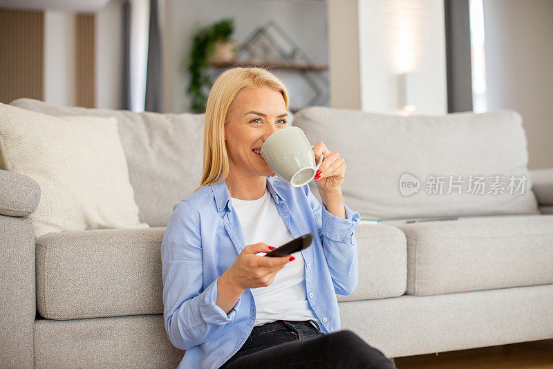 女人在家里享受她最喜欢的电视节目