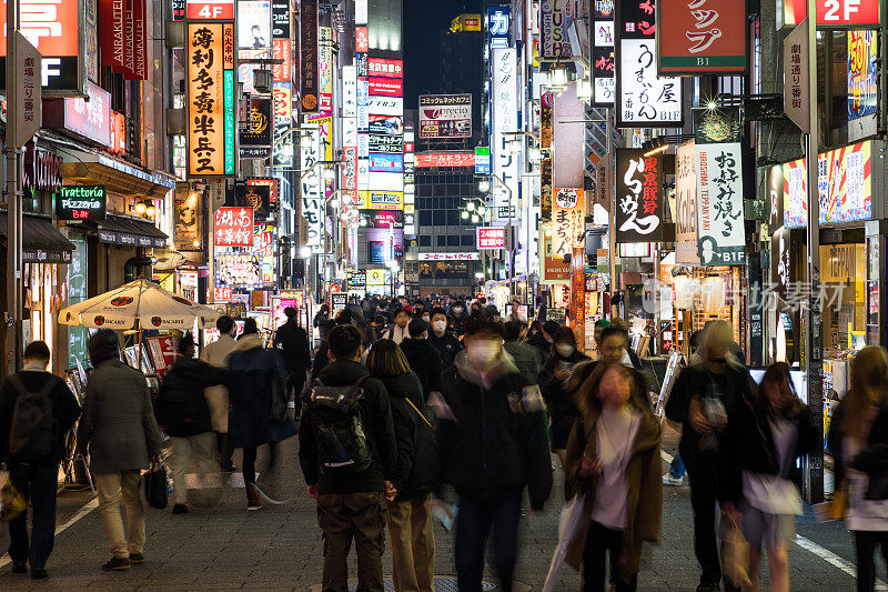 运动模糊拥挤的日本人，亚洲旅行者走在歌舞伎町街红灯区，东京新宿市。亚洲旅游旅游或日本娱乐夜生活派对概念