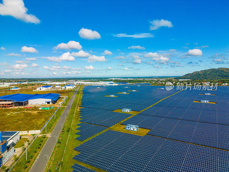 大型可持续发电厂鸟瞰图，多排太阳能光伏板，在蓝天乡村生产清洁生态电能
