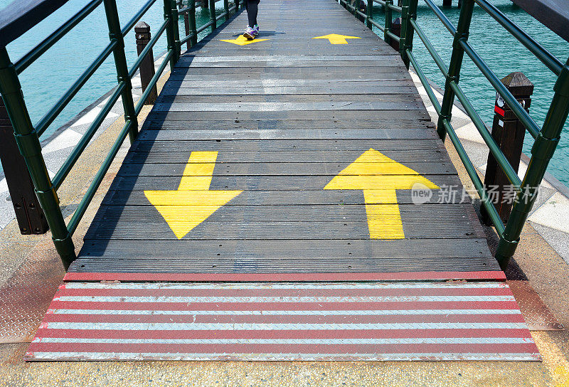 起点的红线和木桥上指向两个方向的双向黄色交通箭头标志
