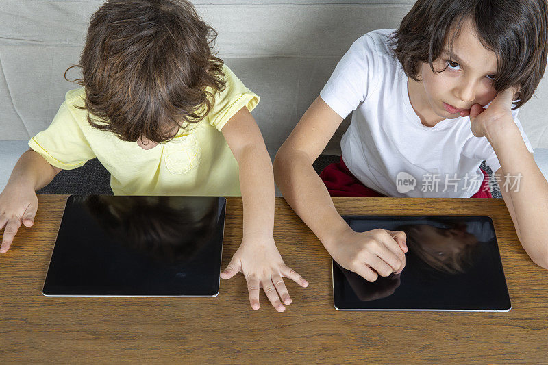 兄弟俩在玩平板电脑。