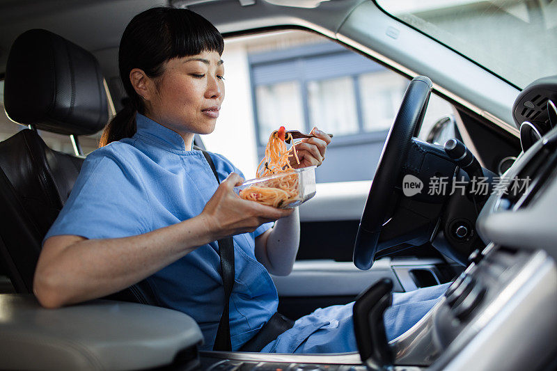 年轻的日本医护人员在车里吃午饭