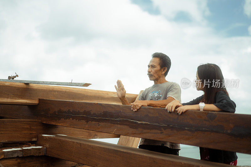 美丽的亚洲女性游客向当地工匠学习造船