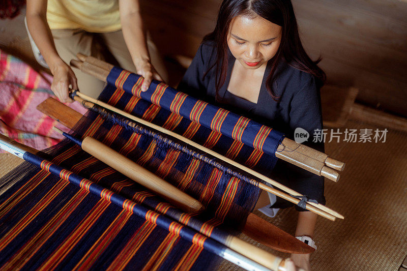 年轻的印尼妇女学习手工编织传统的Tenun布