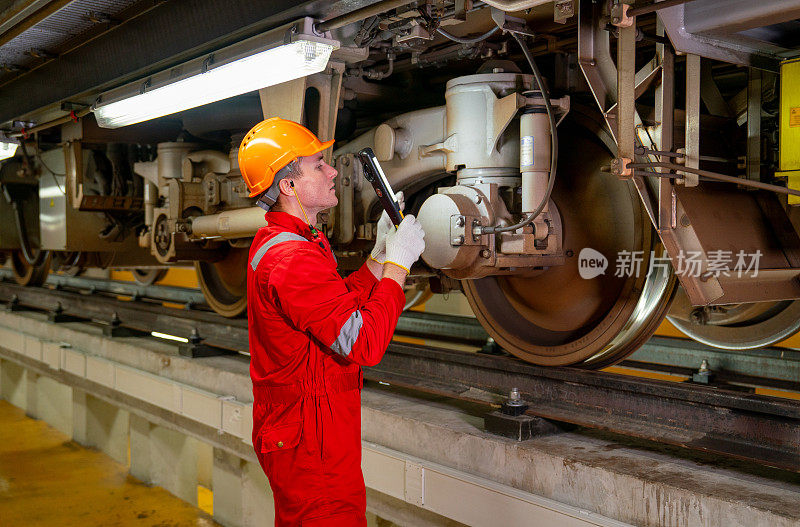 专业技术人员在电气或地铁车辆厂拿着灯管检查和维修部分列车。