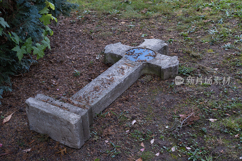 古老的中世纪坟墓倒下的十字架躺在地上，万圣节的概念，时间流逝，生命的终结，在墓地的破坏，践踏宗教基础，