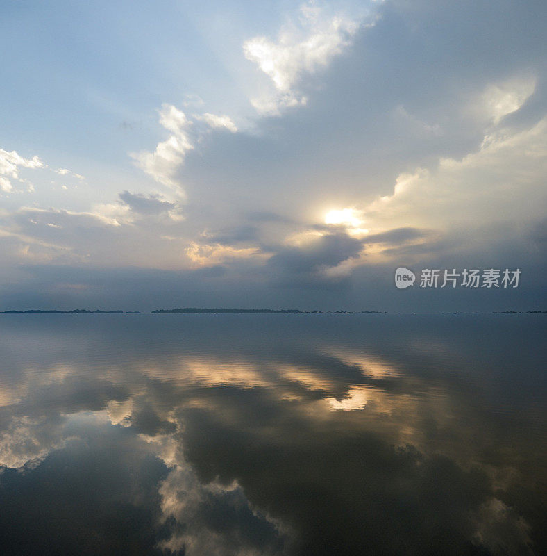 宁静的湖水倒映着多云的天空。康罗湖，德克萨斯州