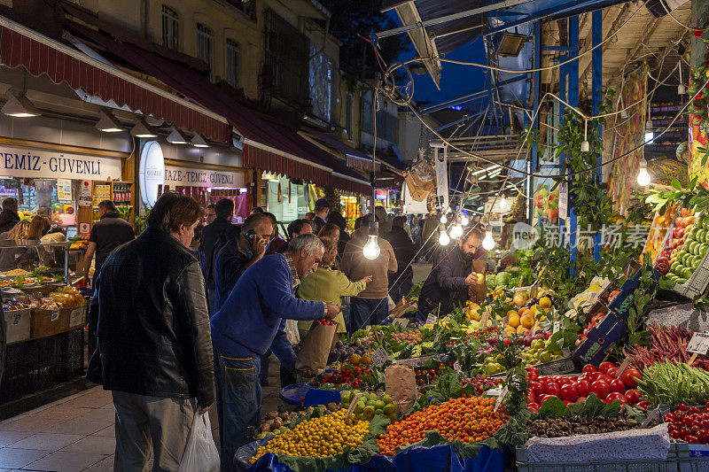 人们在卡迪科伊市场购买新鲜水果和蔬菜。