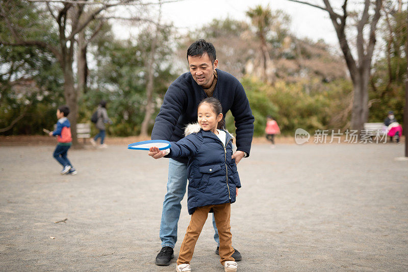 父亲教女儿如何扔飞盘