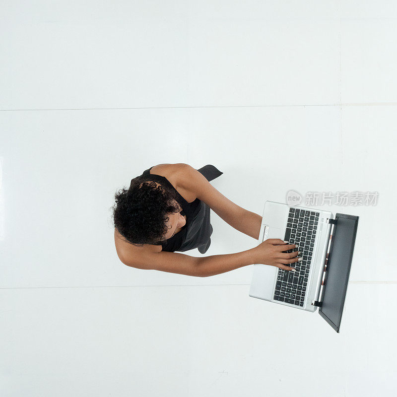 非裔美国女性穿着裙子站着用笔记本电脑