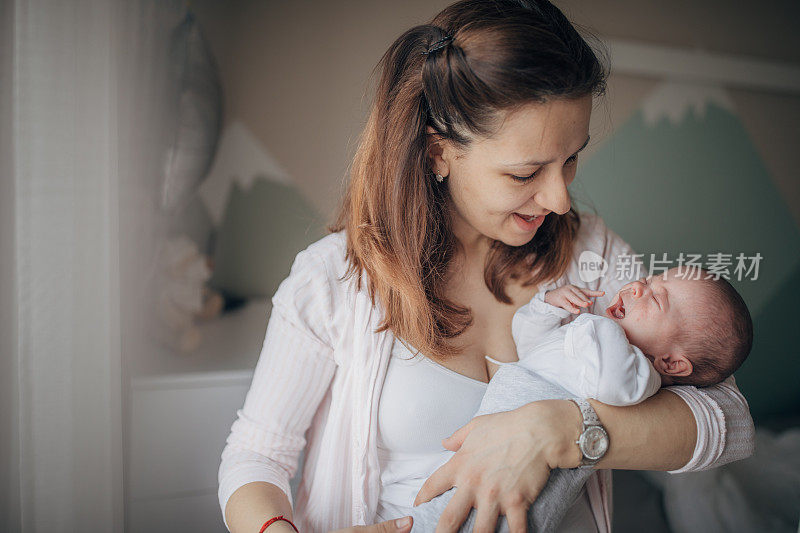 母亲在家里抱着她的男婴