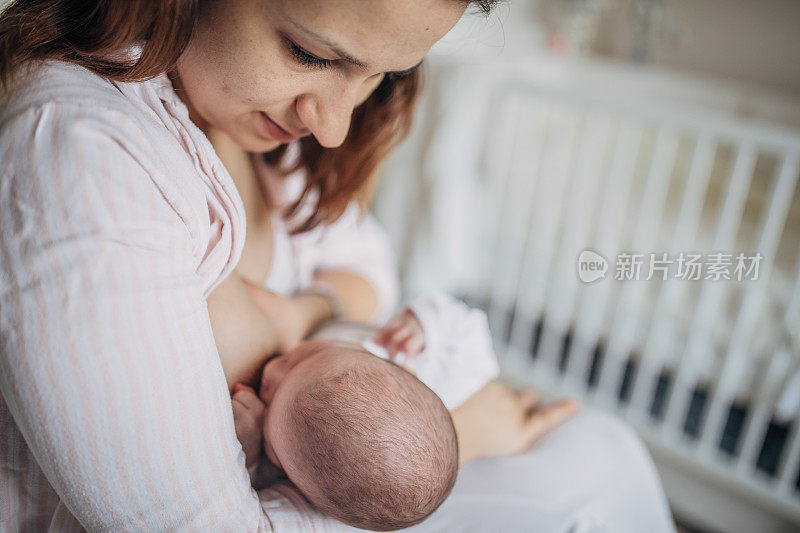 母亲在家里母乳喂养她的男婴