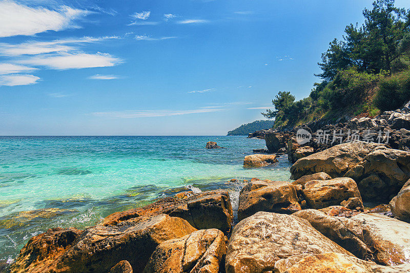 希腊岛上美丽的海滩，岩石嶙峋的海岸线，绿松石般的大海