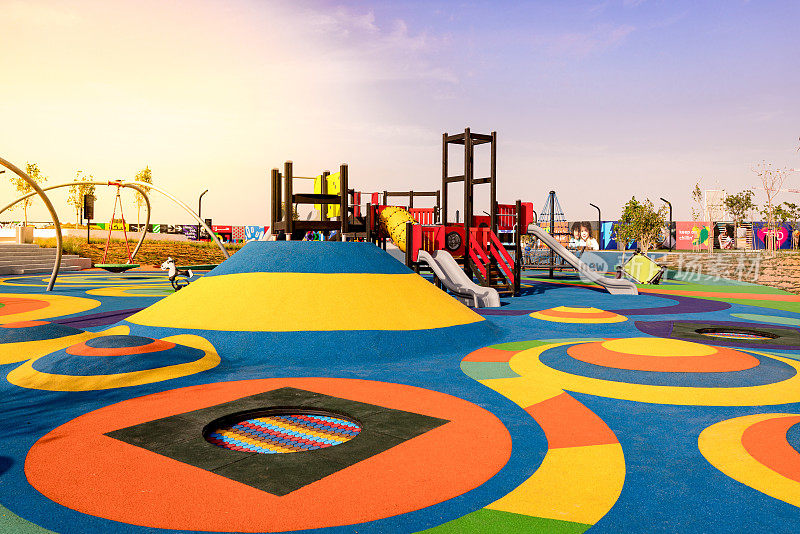 沙迦公园的游乐设施，一座有滑梯和攀岩选项的城堡，有彩色的橡胶地板、土堆和蹦床