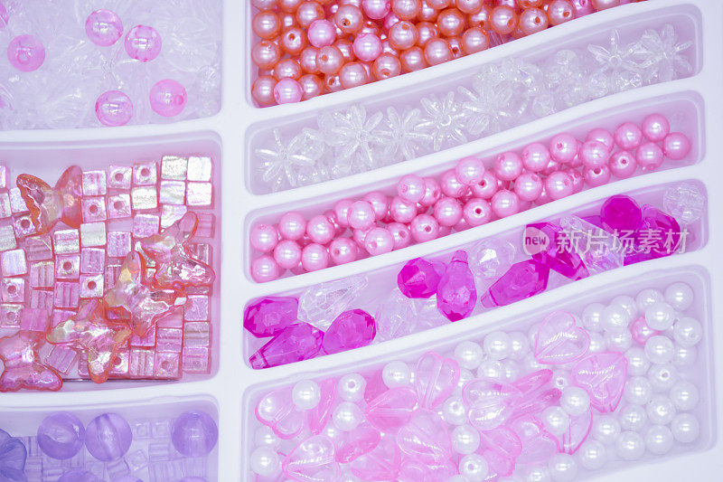 特写各种珍珠和珠粉，橙色，白色，紫罗兰色和透明的工艺品。作为一个微妙的背景。有选择性的重点