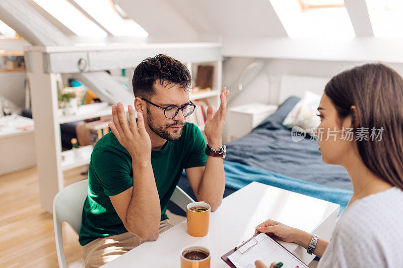 一个年轻人正在和一个年轻的心理治疗师谈论他的问题