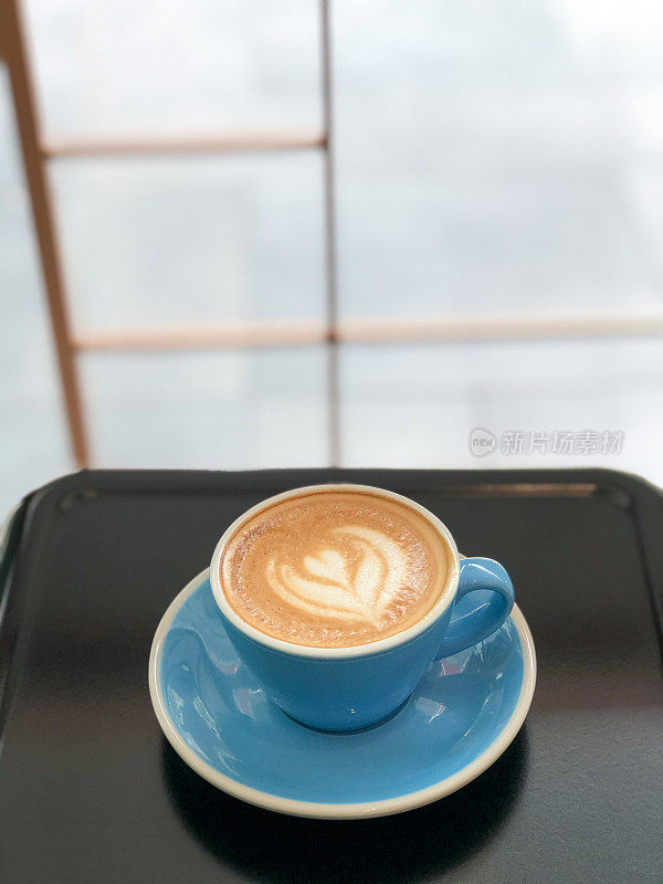 蓝色咖啡杯的心形泡沫艺术咖啡