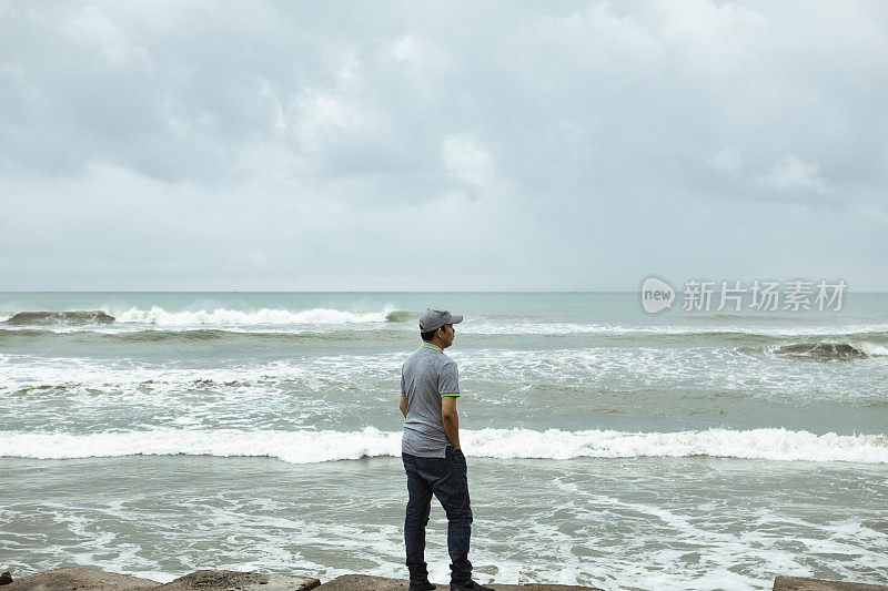 一个悲伤而孤独的人站在印度洋前