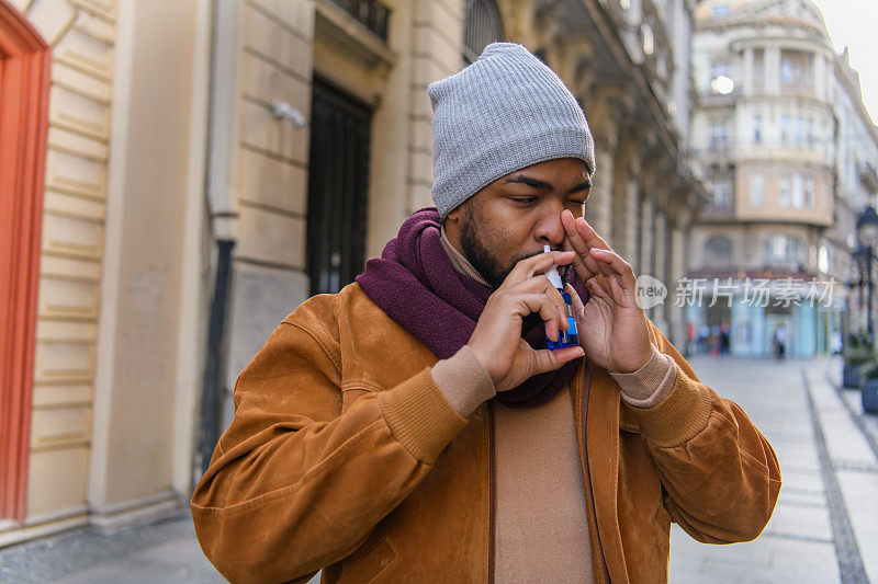 年轻的非洲裔美国人戴着防护面罩，在外面的大自然中患上了鼻窦炎。