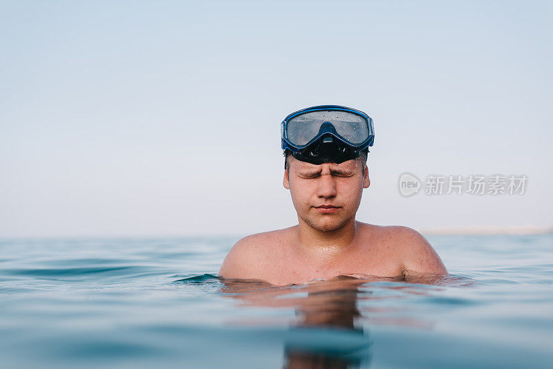 在海里戴着潜水镜的男孩