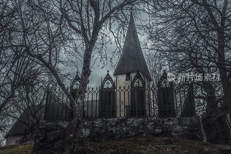 令人毛骨悚然的中世纪教堂和墓地，还有一排黑色的铁墓碑