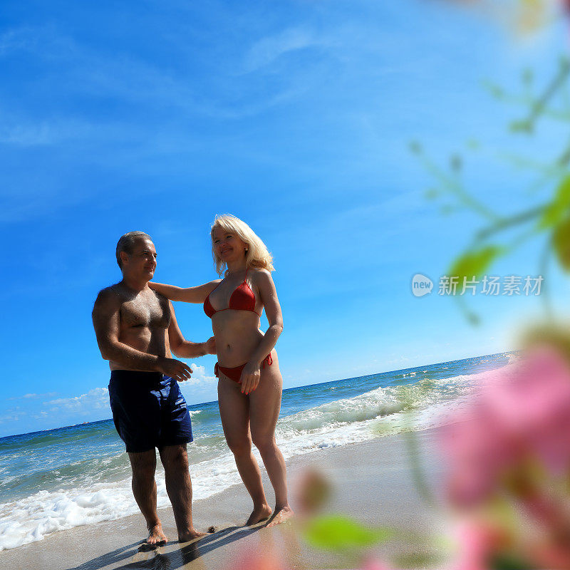 美丽成熟的男人和女人在热带蜜月海滩度假