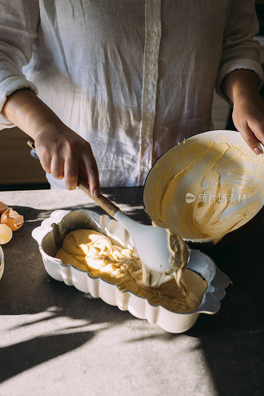 匿名超重的职业女面包师将面团倒入烘焙模具