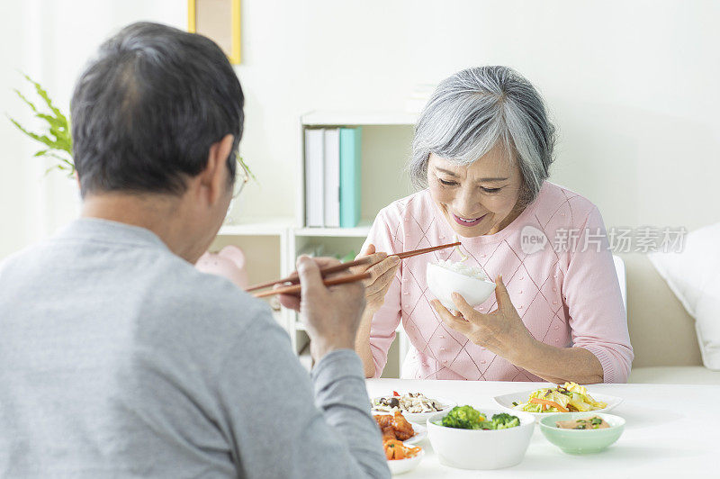 老年夫妻坐在餐桌前用餐