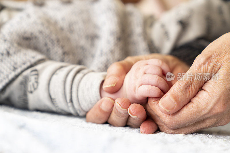 奶奶牵着孩子的手。母亲和孩子的手。家庭的概念