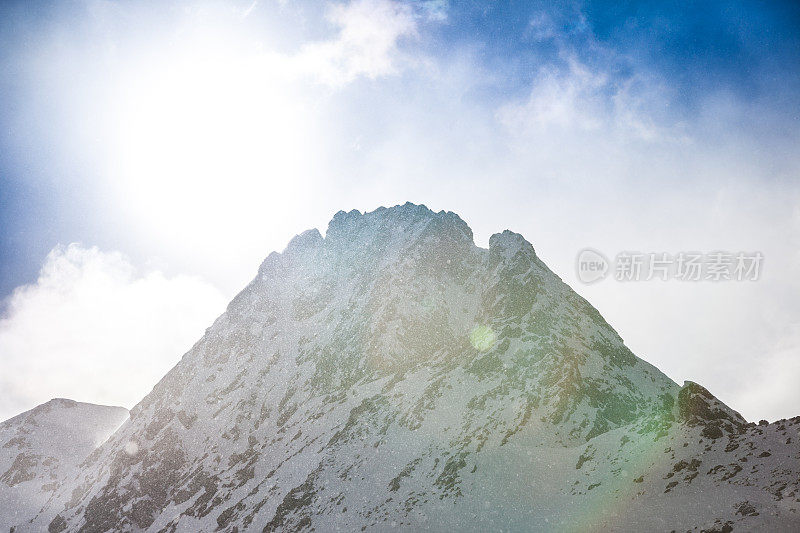 雪山在雪片中闪耀着阳光