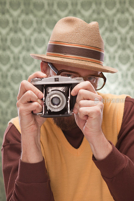 一名男子正在用复古相机拍照