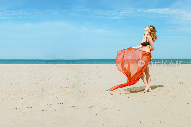 美丽的女人在海滩上穿着丝绸布莎笼