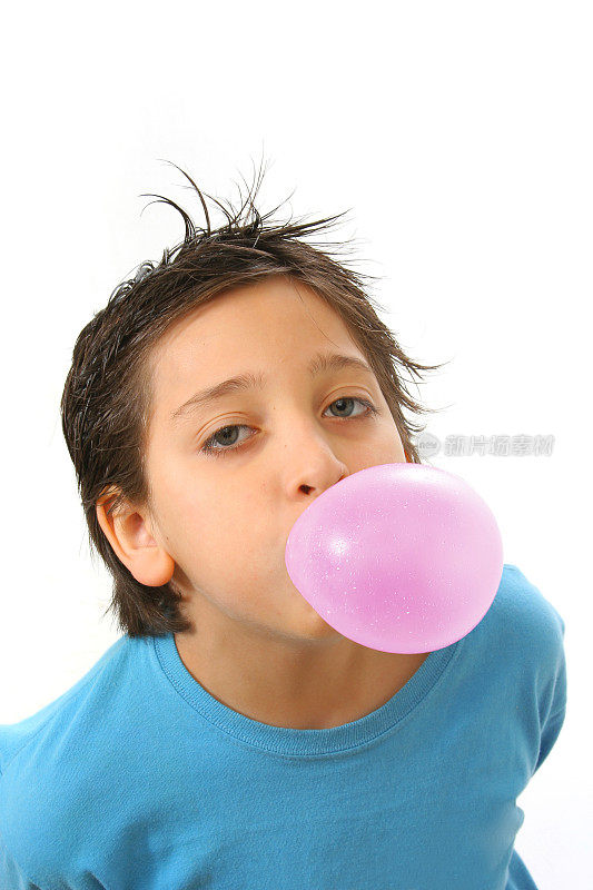 男孩吹着粉红色的泡泡糖