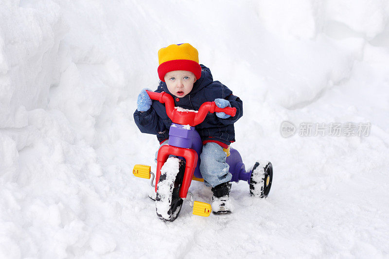 试图在雪地里骑自行车的男孩