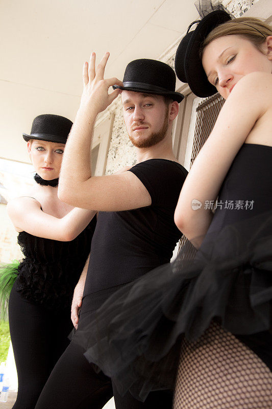 一群穿着戏服的爵士芭蕾舞者在镜头前摆姿势。