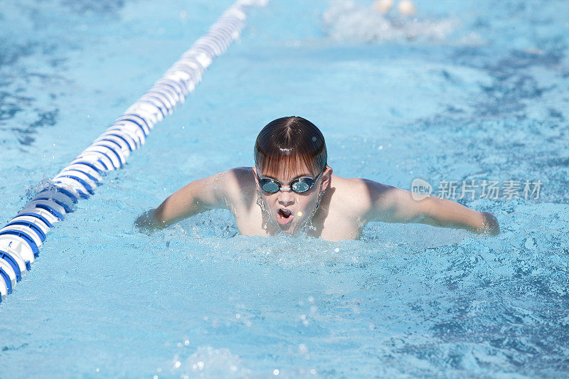 年轻的男孩游泳蝶泳