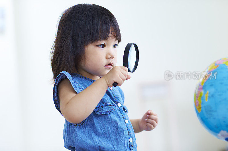 亚洲小女孩用放大镜