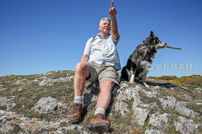 一个成熟的男人和他的狗在威尔士徒步旅行