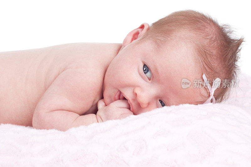 新生女婴躺在粉红色的毯子上