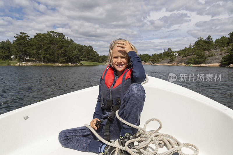 快乐的8岁，穿着救生衣在船上。瑞典