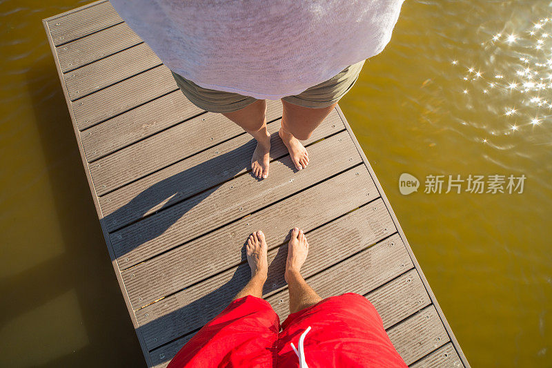 年轻夫妇在湖码头拍下他们的脚