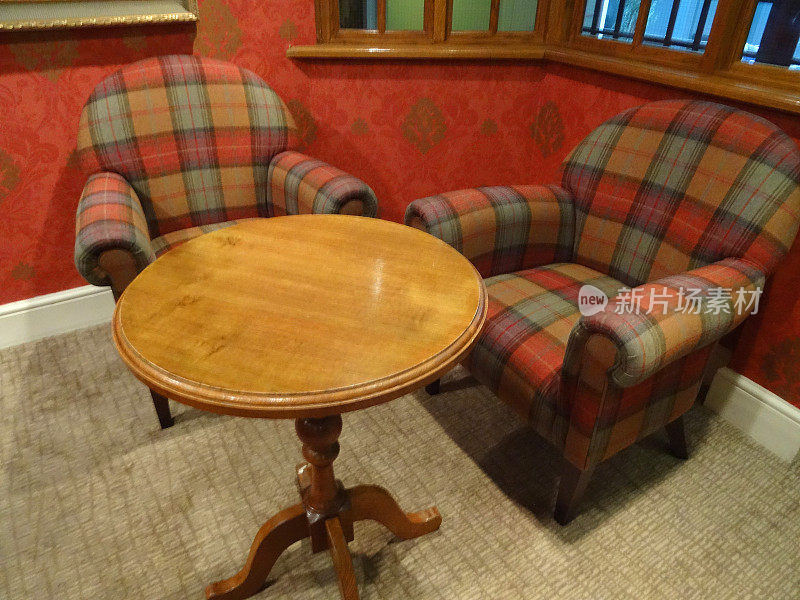 形象的格子布扶手椅，古董圆形木制咖啡桌