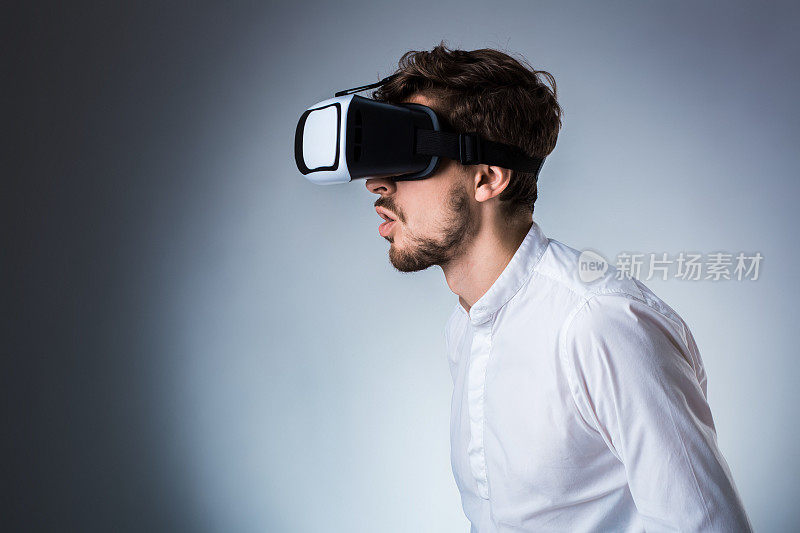 一个年轻人使用VR头盔的侧视图