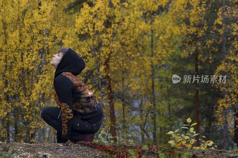 那个女孩坐在秋天的森林里